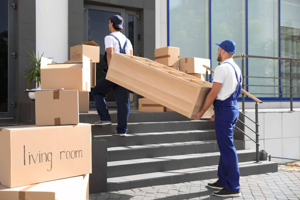 Two long-distance movers carrying a large wooden crate