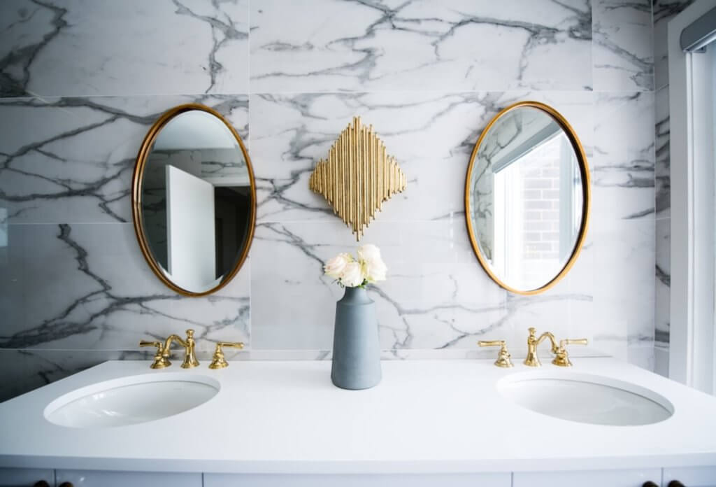 A white sink with mirrors
