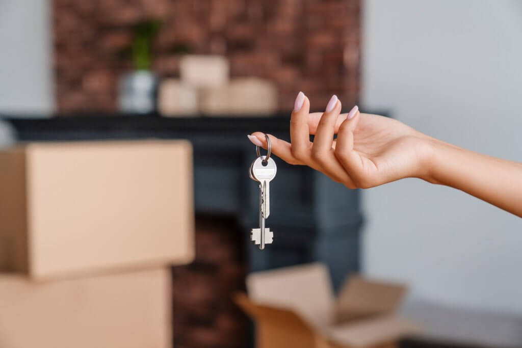 A person holding a key after cross-country moving