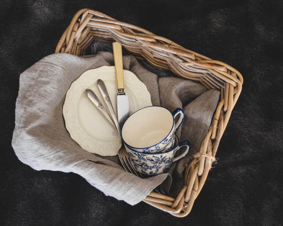 Mugs and places in a wooden basket