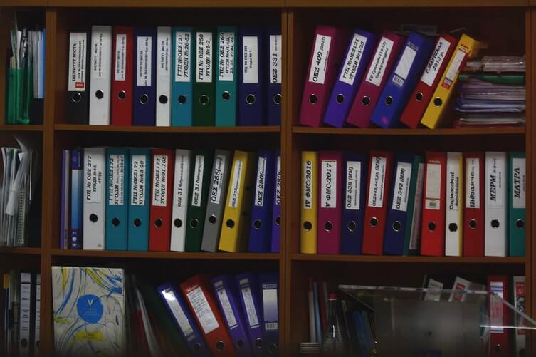 A shelf with different colored folders