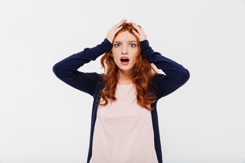 Confused excited young redhead lady