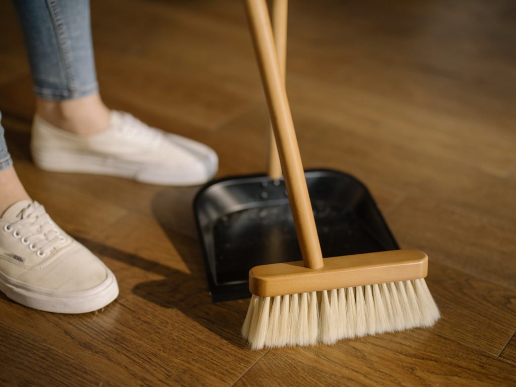 Cleaning with a wooden broom