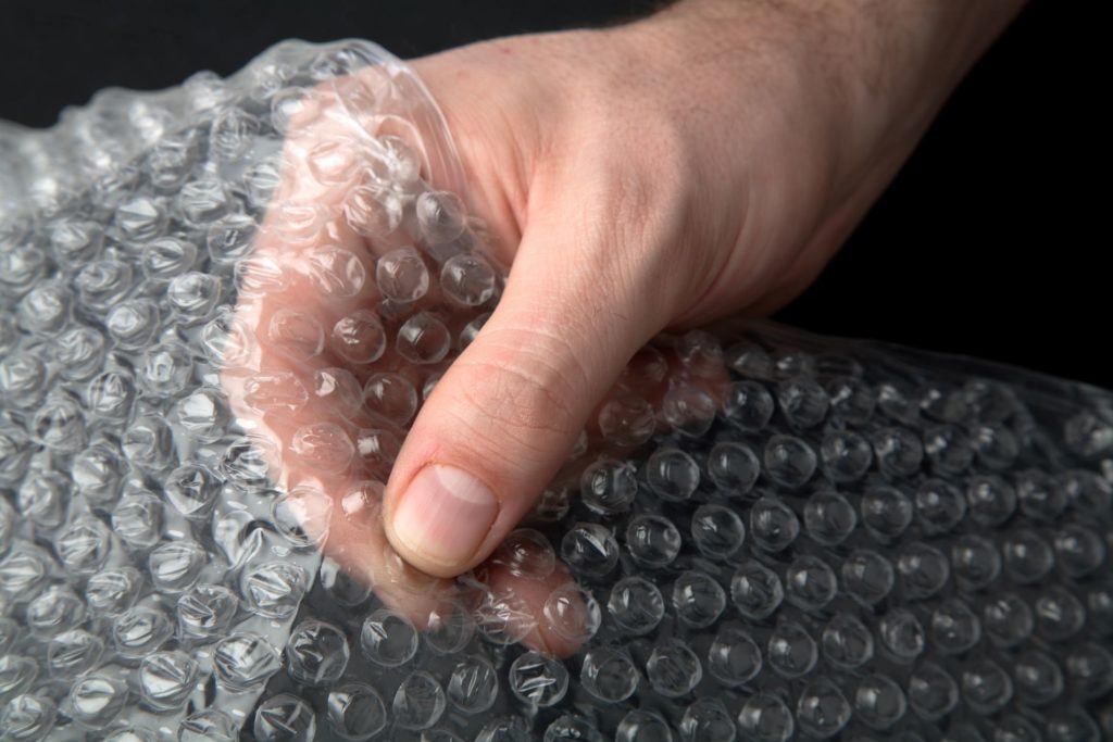 A person holding bubble wrap before cross-country moving