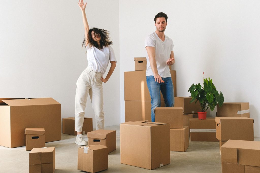 Dancing couple unpacking after cross-country moving