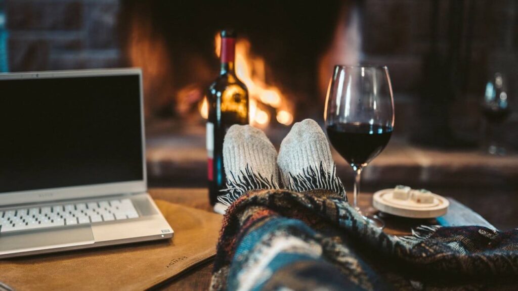 A person with a laptop and a glass of wine after cross-country moving 