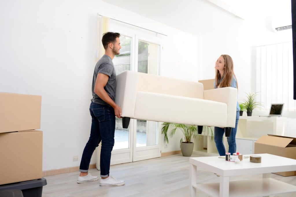 Two people relocating a sofa