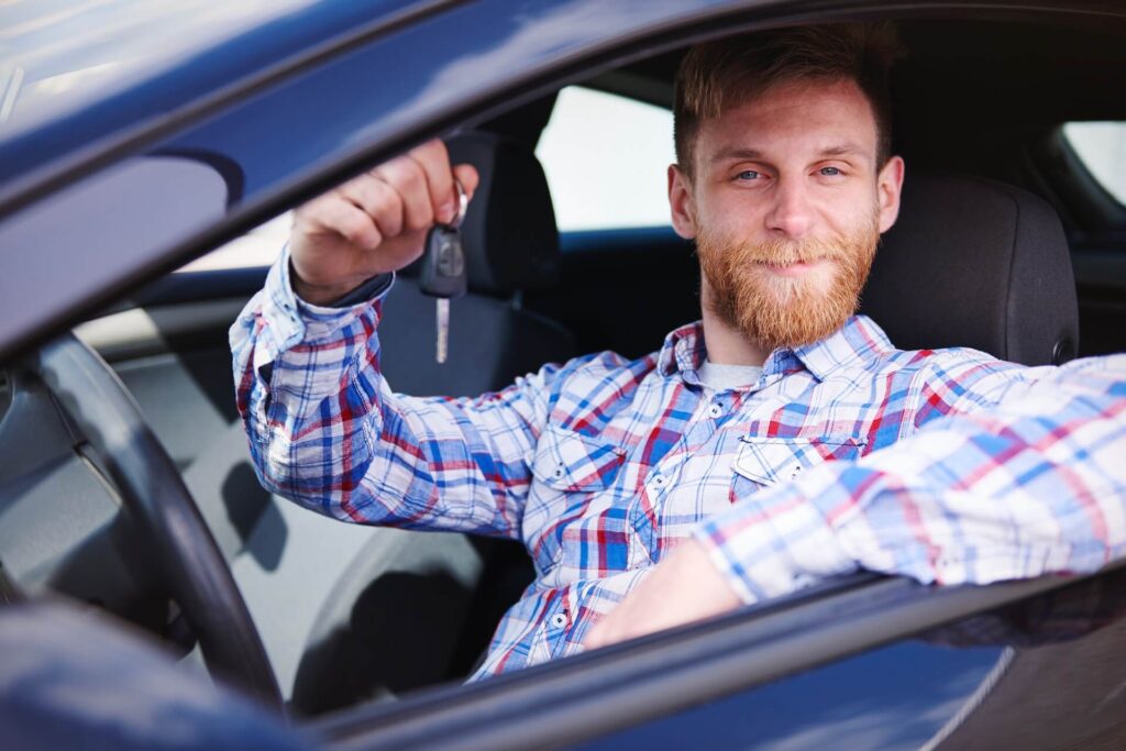 A man smiling and holding keys