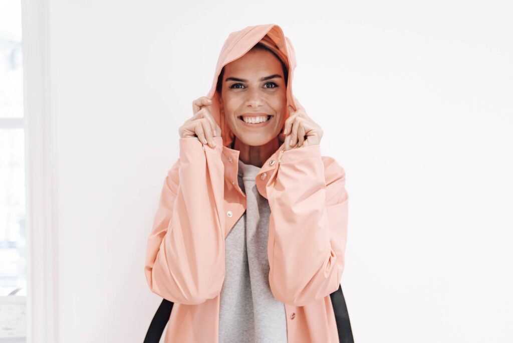 Woman smiling dressed in a coat with a hood 
