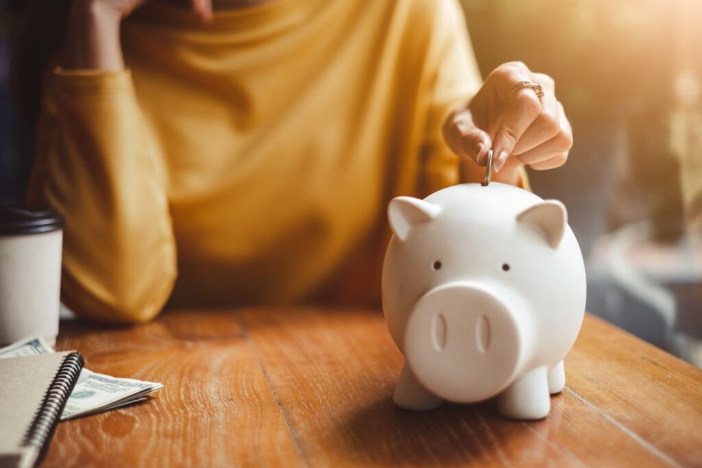Woman putting a coin in piggy bank