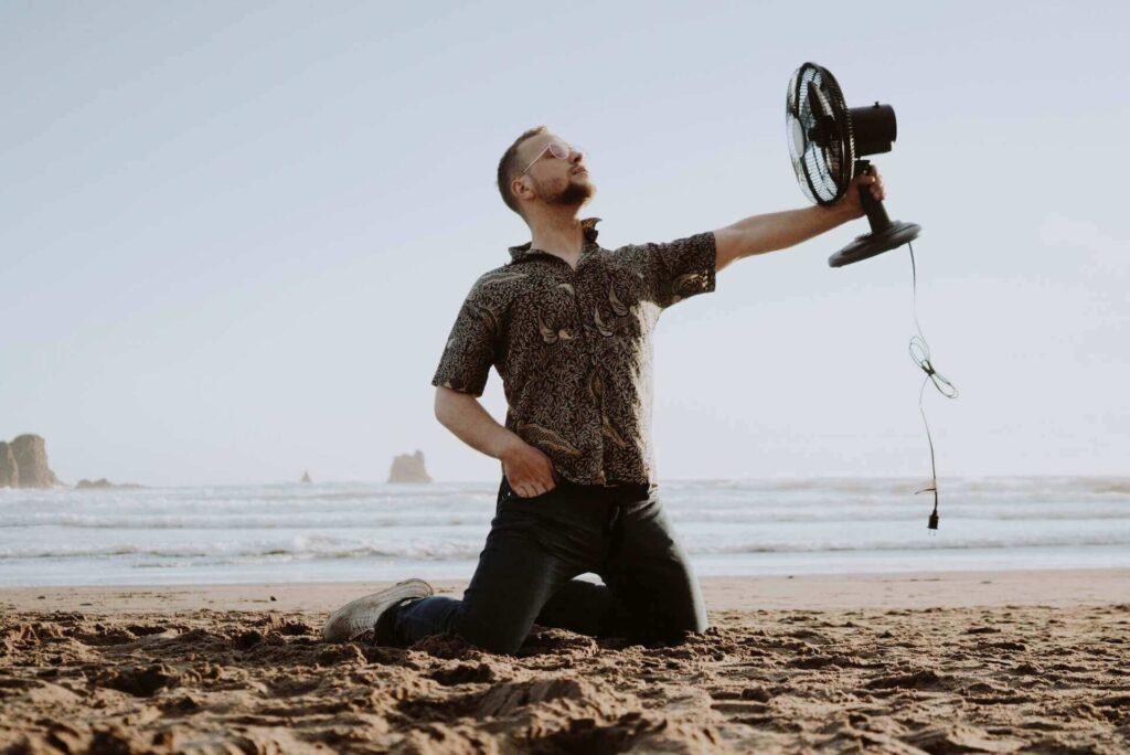A man holding a fan on a beach