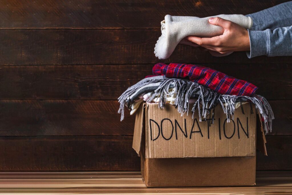A person sorting clothes for donation before long-distance moving