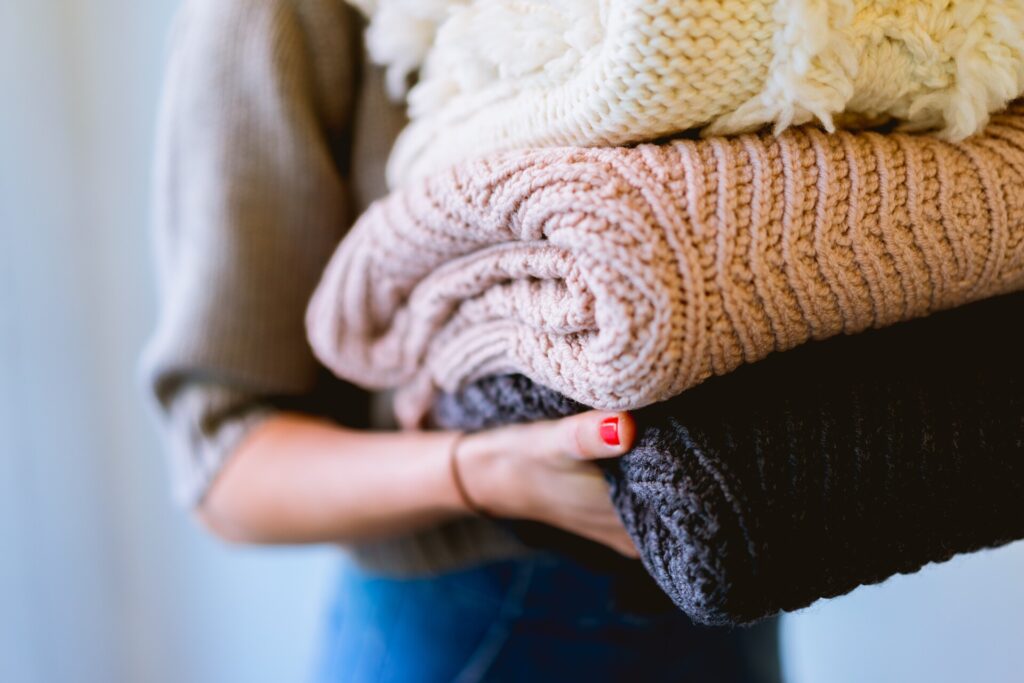 Person Holding sweaters