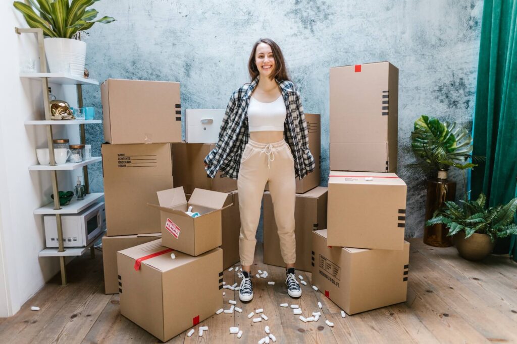 A woman standing surrounded by boxes