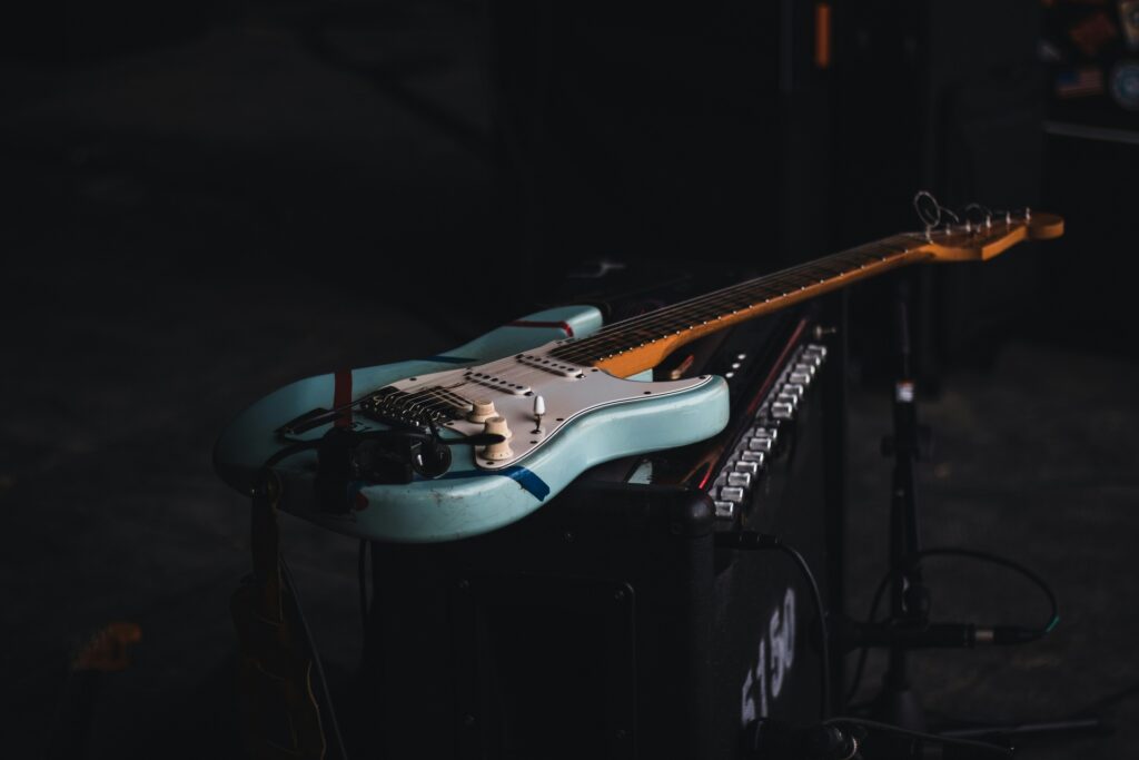 A guitar on a black amp on stage