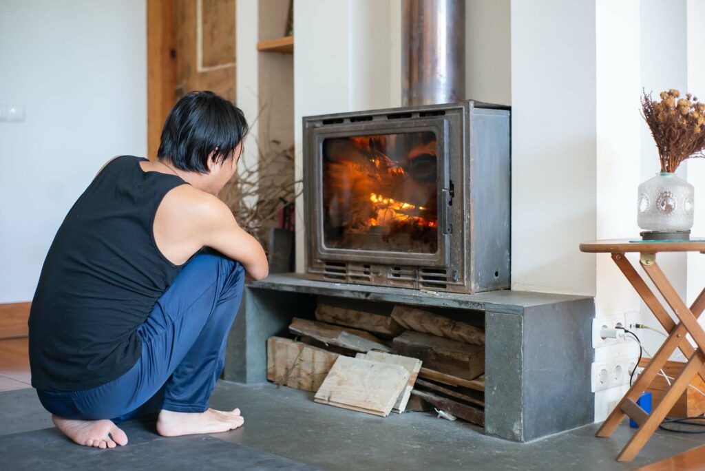 Man sitting in front of a wood stove