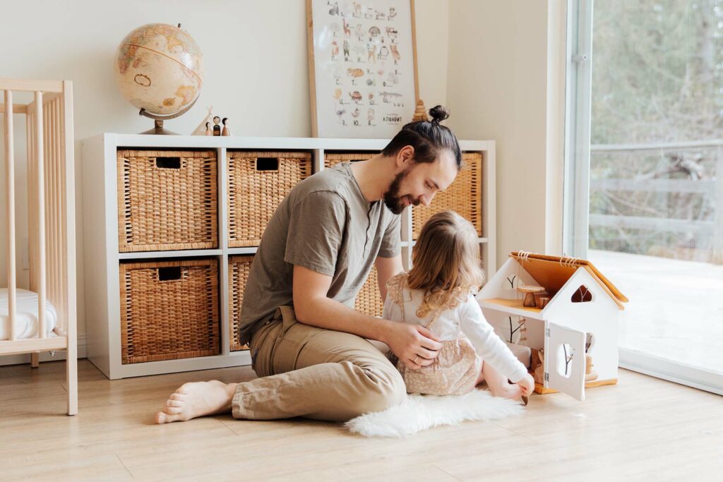 A man sitting on the floor with his little daughter