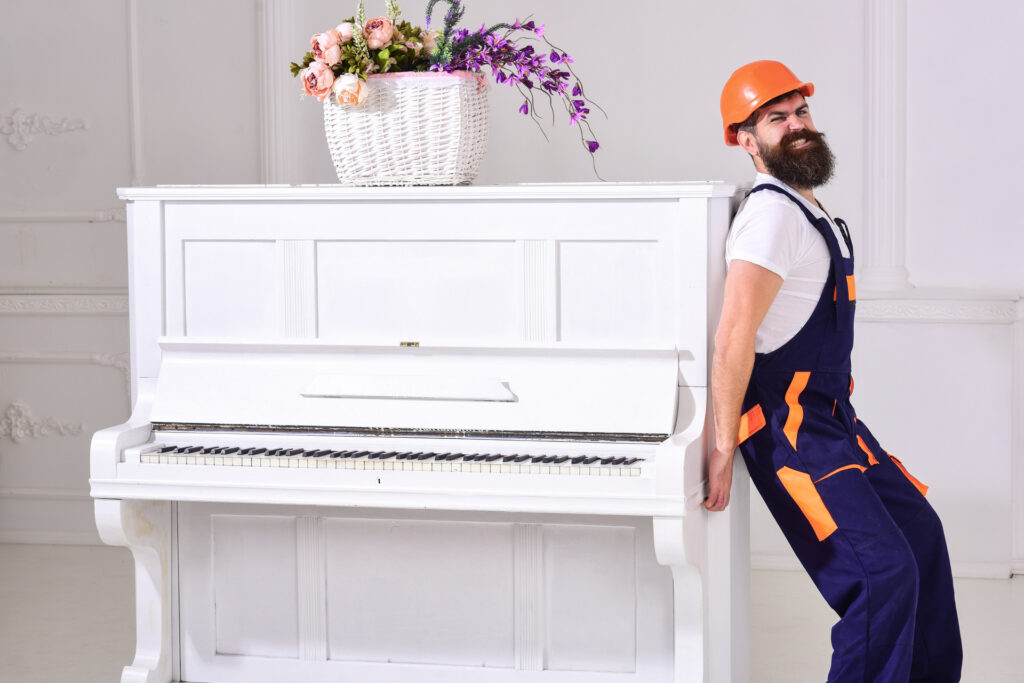 Movers relocating a piano inside a Manhattan apartment