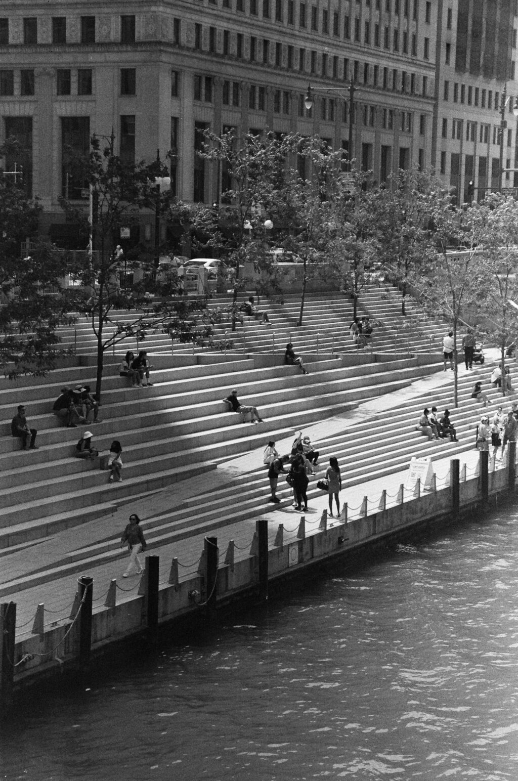 Black and white photo of people resting on city steps.